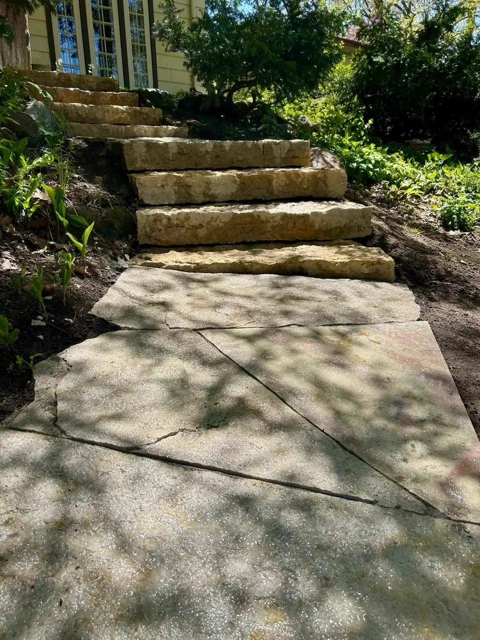 Shaded stone steps leading to a flagstone walkway
